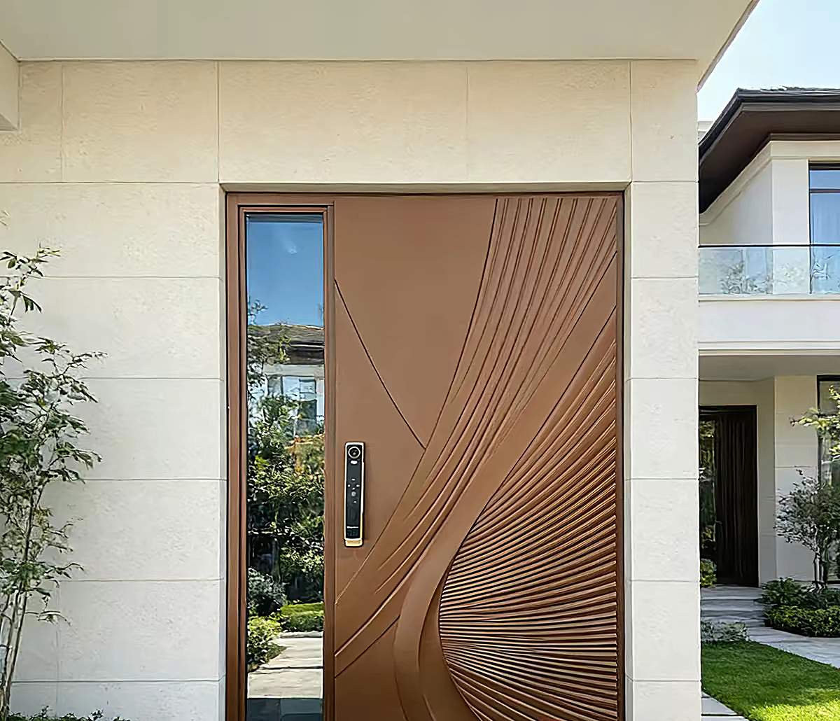 Bronze entrance door with carved wave pattern beside a glazed side panel