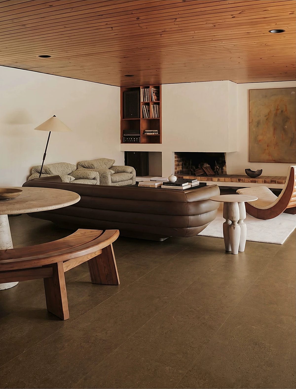 A timber-ceilinged living room over a warm-toned stone-look floor