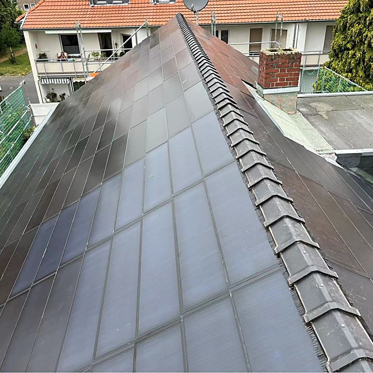 Roof slope fully laid with dark solar roof tiles