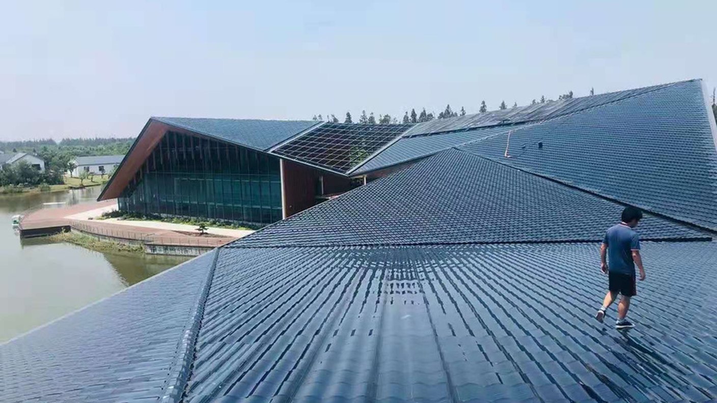 An installer standing on a completed solar tile roof